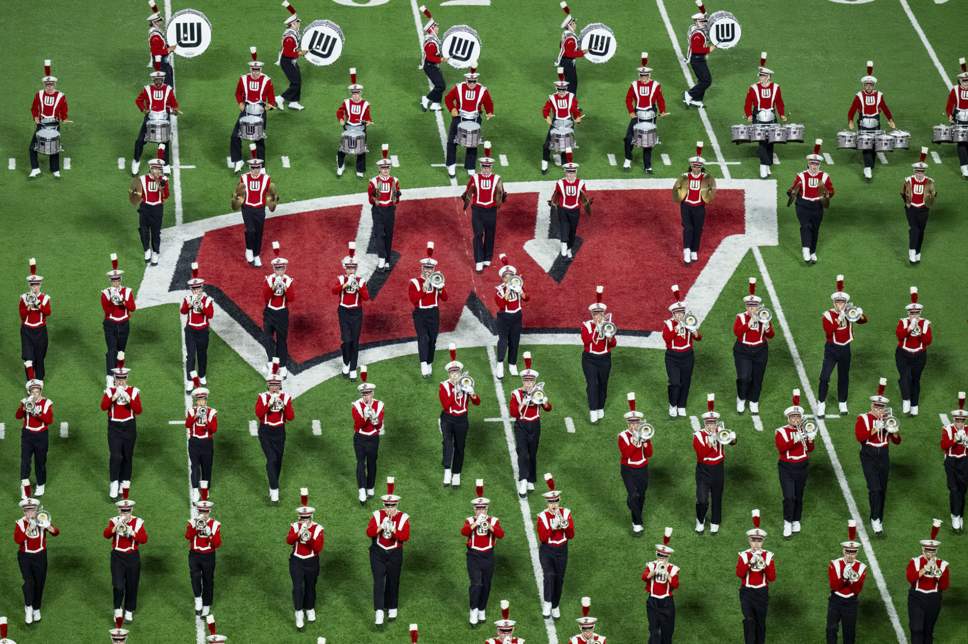 Rows of UW Marching Band members perform on the center logo of the Camp Randall field. 