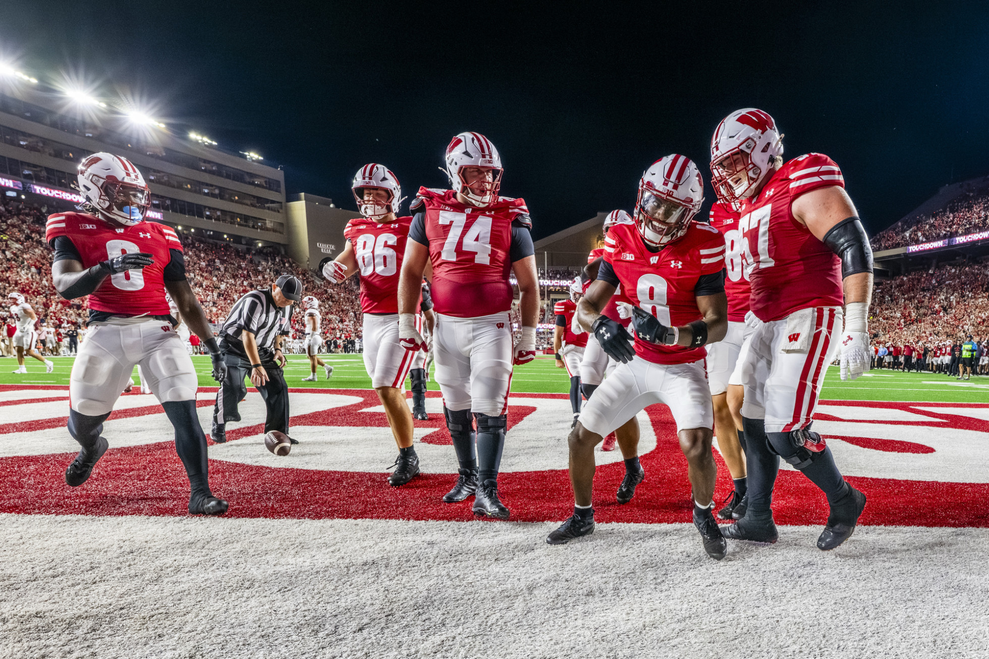Badger football players celebrate with each other in the end zone. 