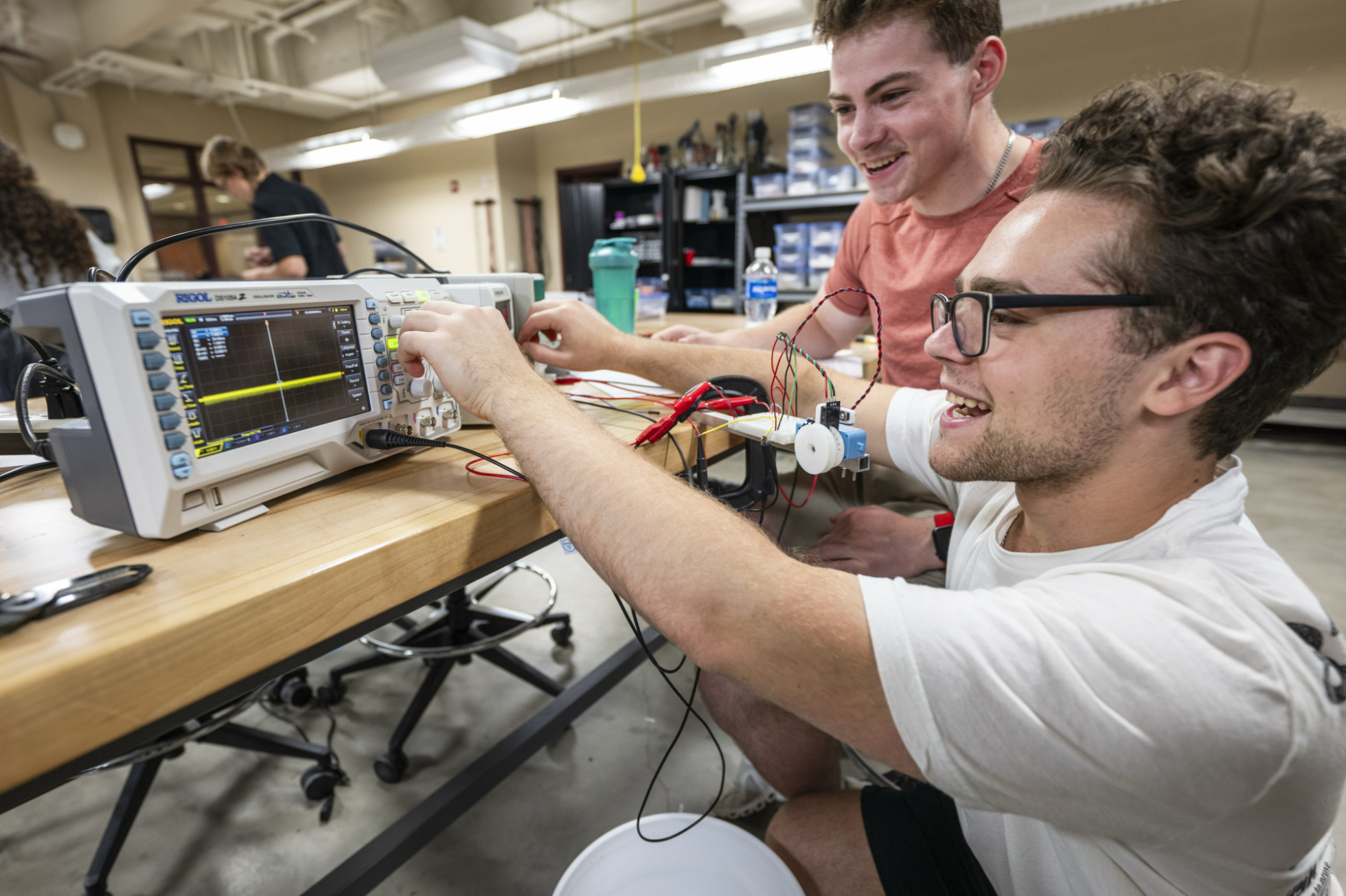 Two students view the screen that shows the measurements of their lab experiment.