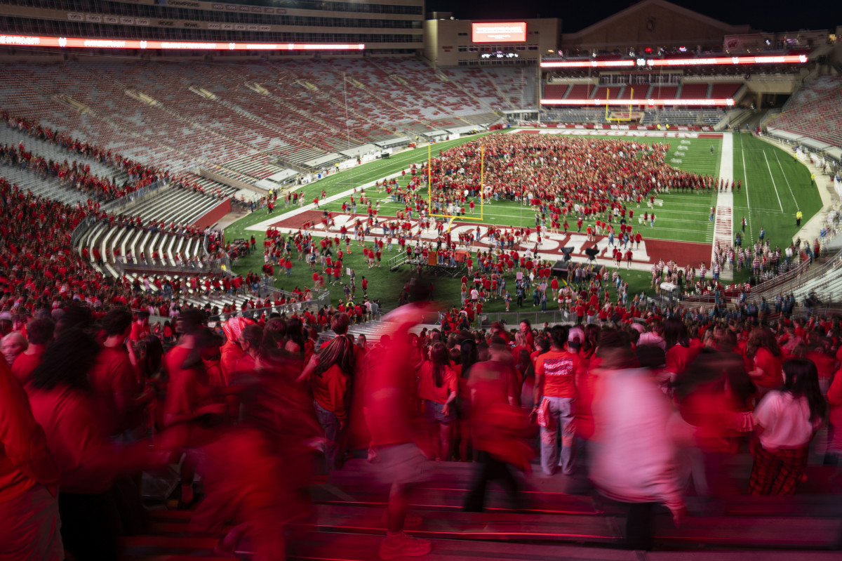 Students watch from the stands as others start to form a W.