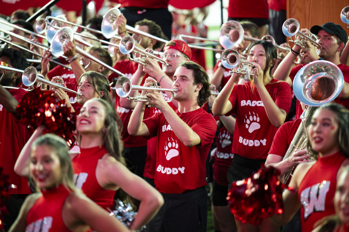 Band members wearing red play their instruments.