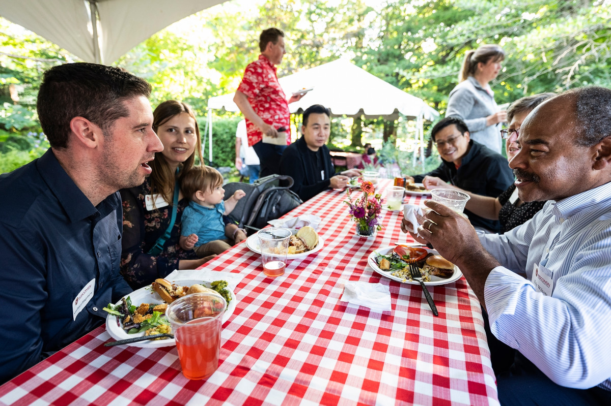Wilconts and Hagenow sit on opposite sides of the picnic table and engage in friendly conversation.