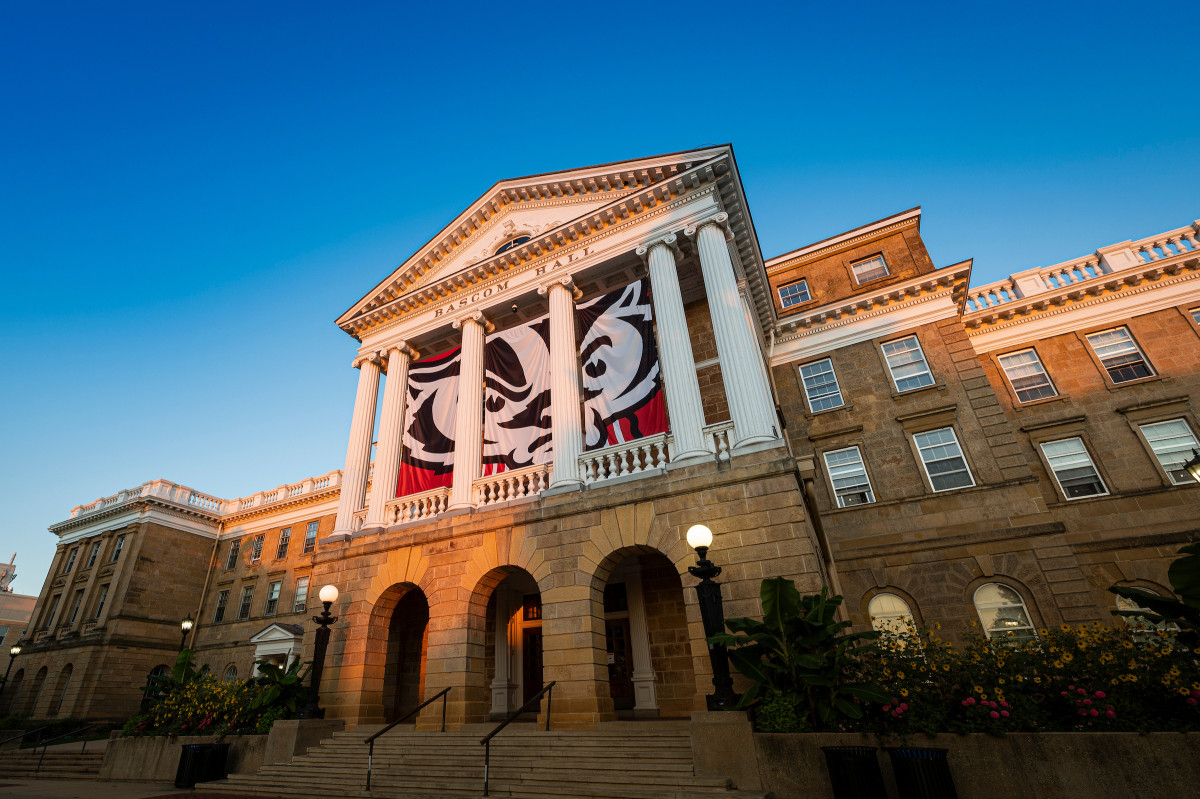 A front-facing photo of Bascom Hall, with a Bucky Badger logo on the banner.