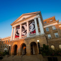 A front-facing photo of Bascom Hall, with a Bucky Badger logo on the banner.