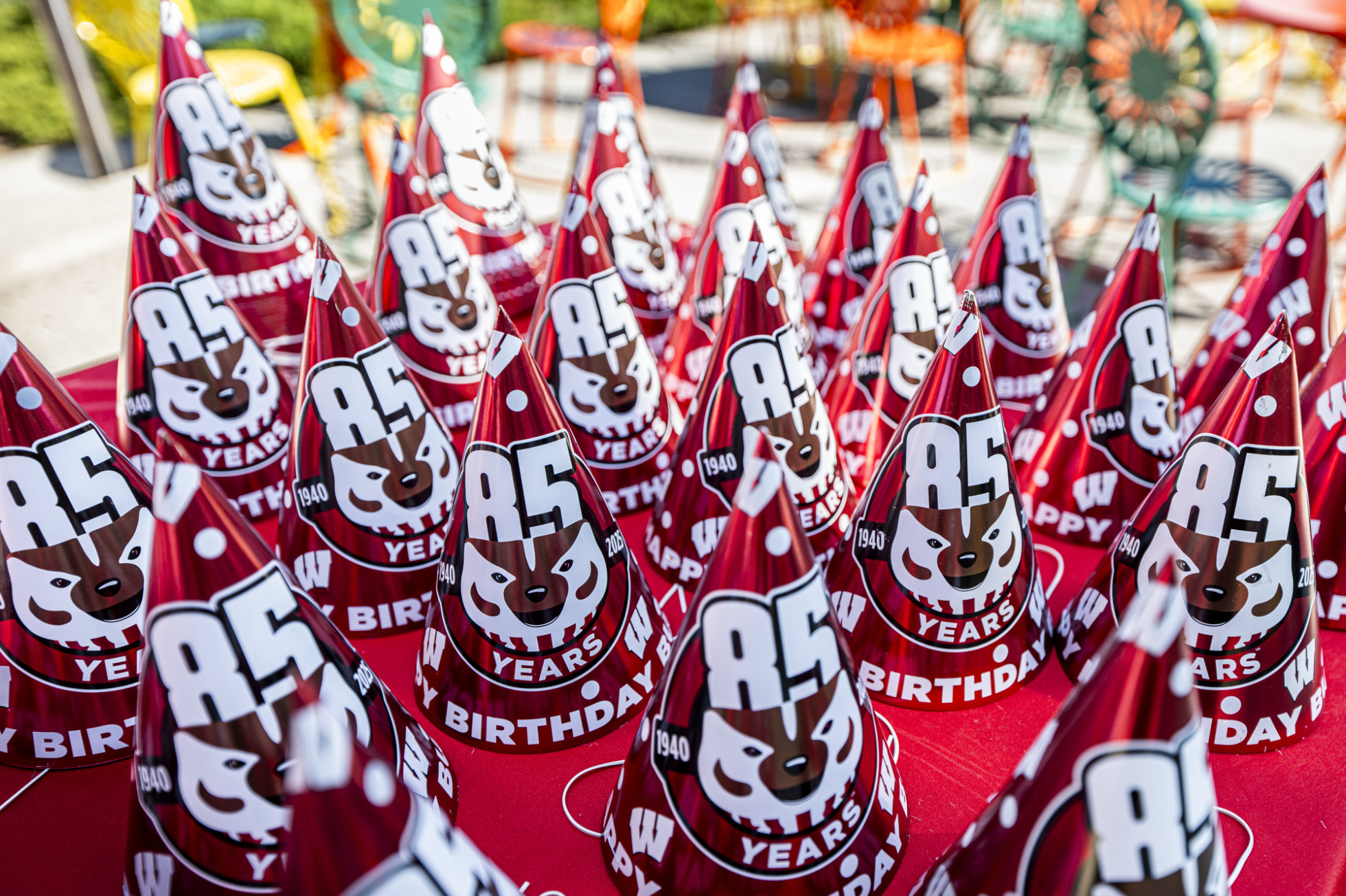 Rows of birthday hats with Bucky Badger's face and the words "85 years" and "happy birthday"