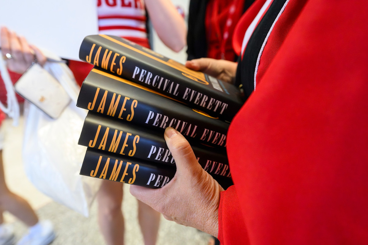 A close up of Chancellor Mnookin holding four copies of the Go Big Read book.