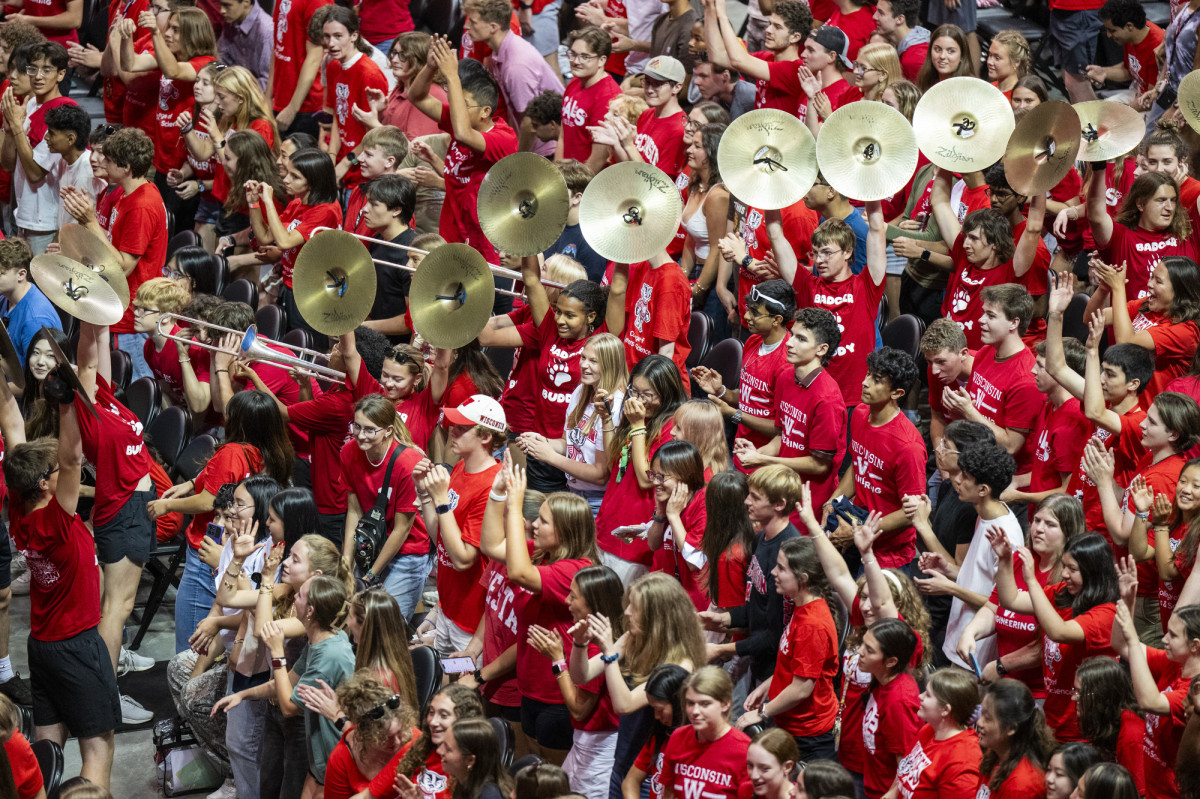 Students, wearing mostly red, fill the stands at the Kohl Center. 