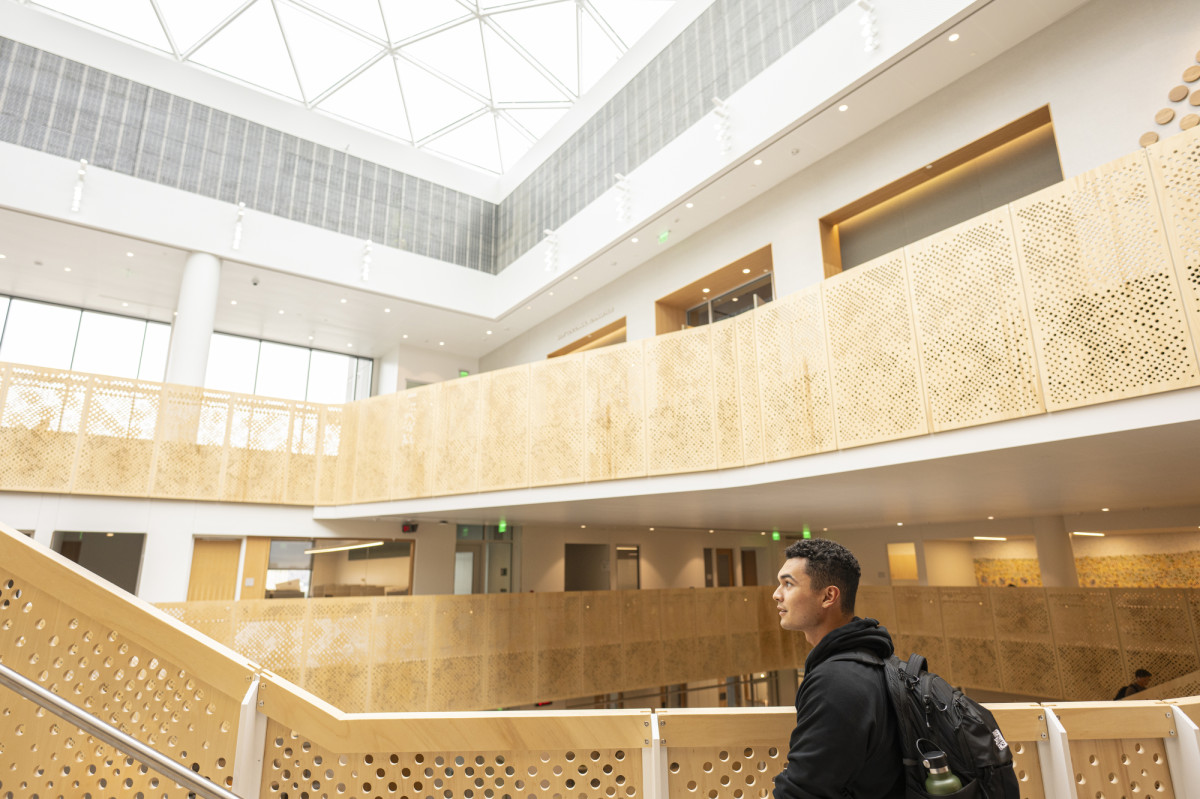 Miguel walks toward the open stairs in Morgridge Hall.