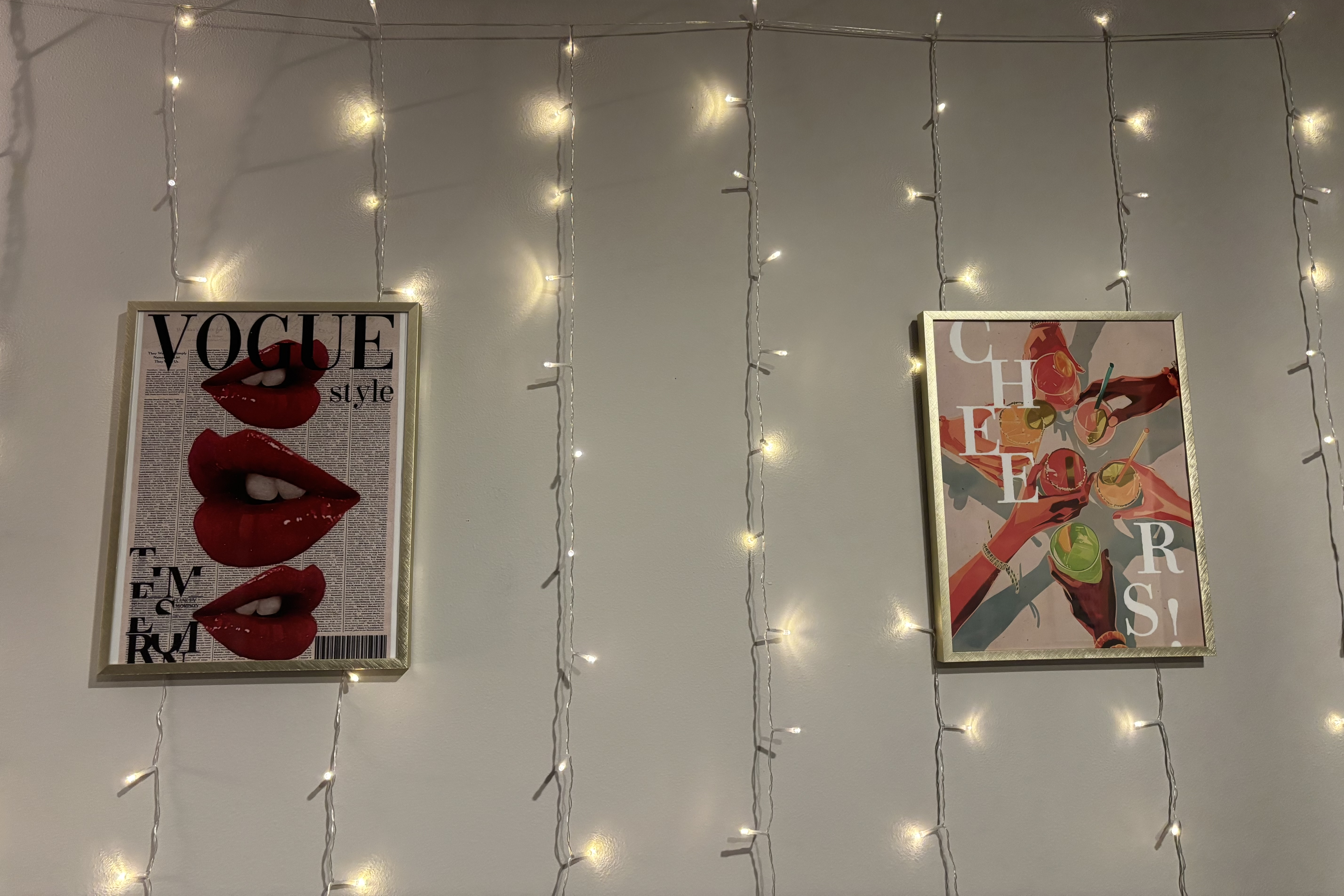 Some lights hang from a wall, along with two photos.
