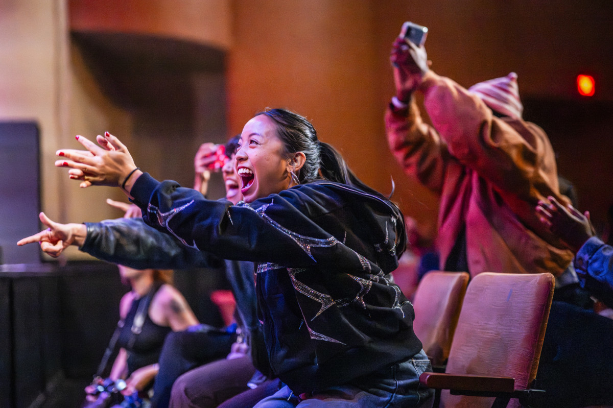 Students sit in the seats in Shannon Hall and cheer on fellow students who perform on stage. 