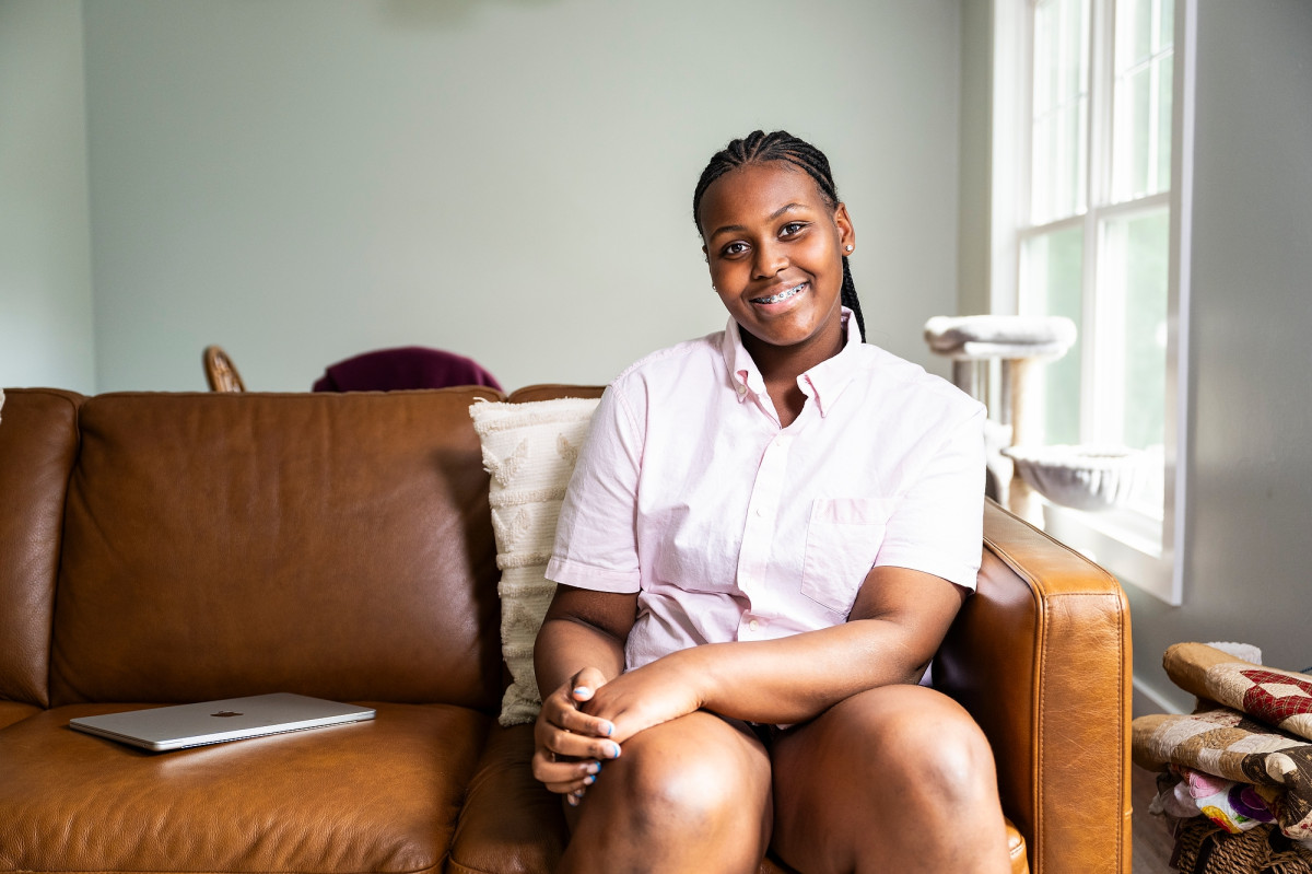 A close-up of Tinnon sitting on the sofa in her living room.