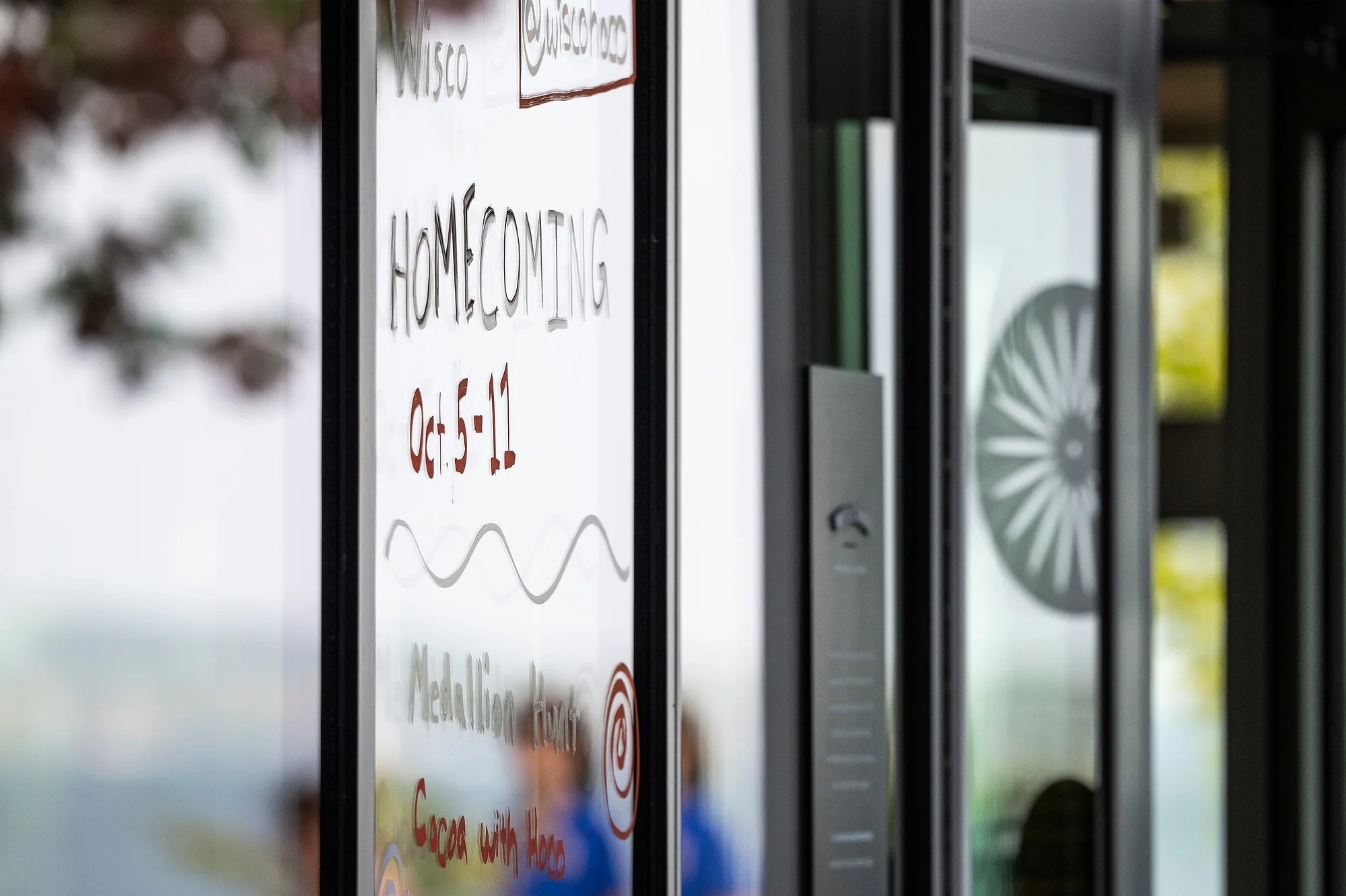 A close-up of one of the window designs shows the dates for this year's homecoming celebration.