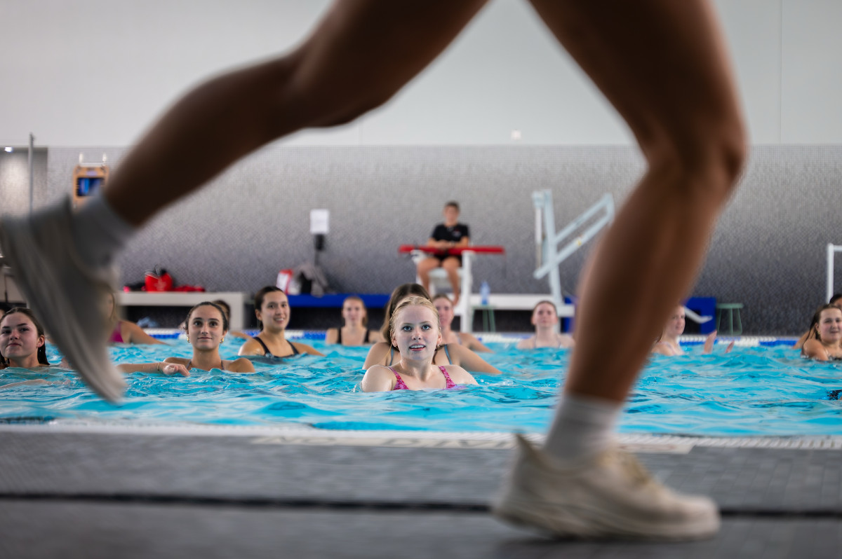 A view of the instructor's feet in a running stance and students following along in the water