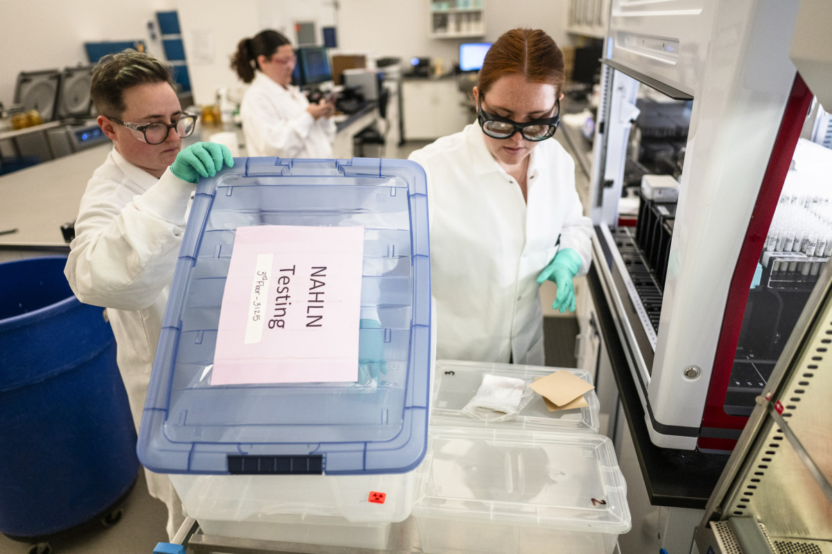 Technicians Asia Johnson and Maddie Myrick load samples into a transport box as they test milk samples.