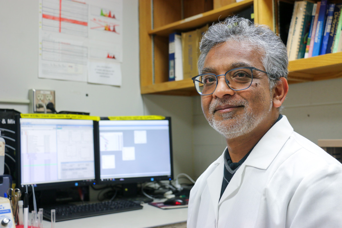 A portrait of professor Marulasiddappa Suresh, in front of his work station.