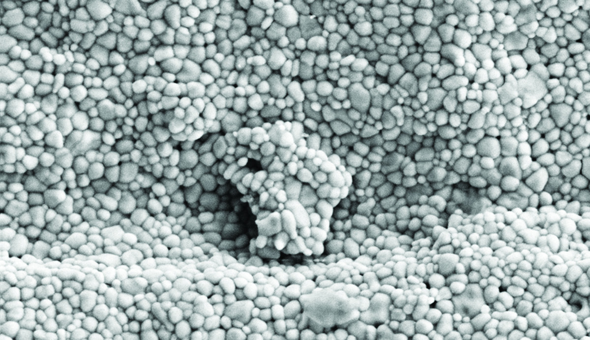 Black and white image of tiny spheres clumped together, resembling styrofoam.
