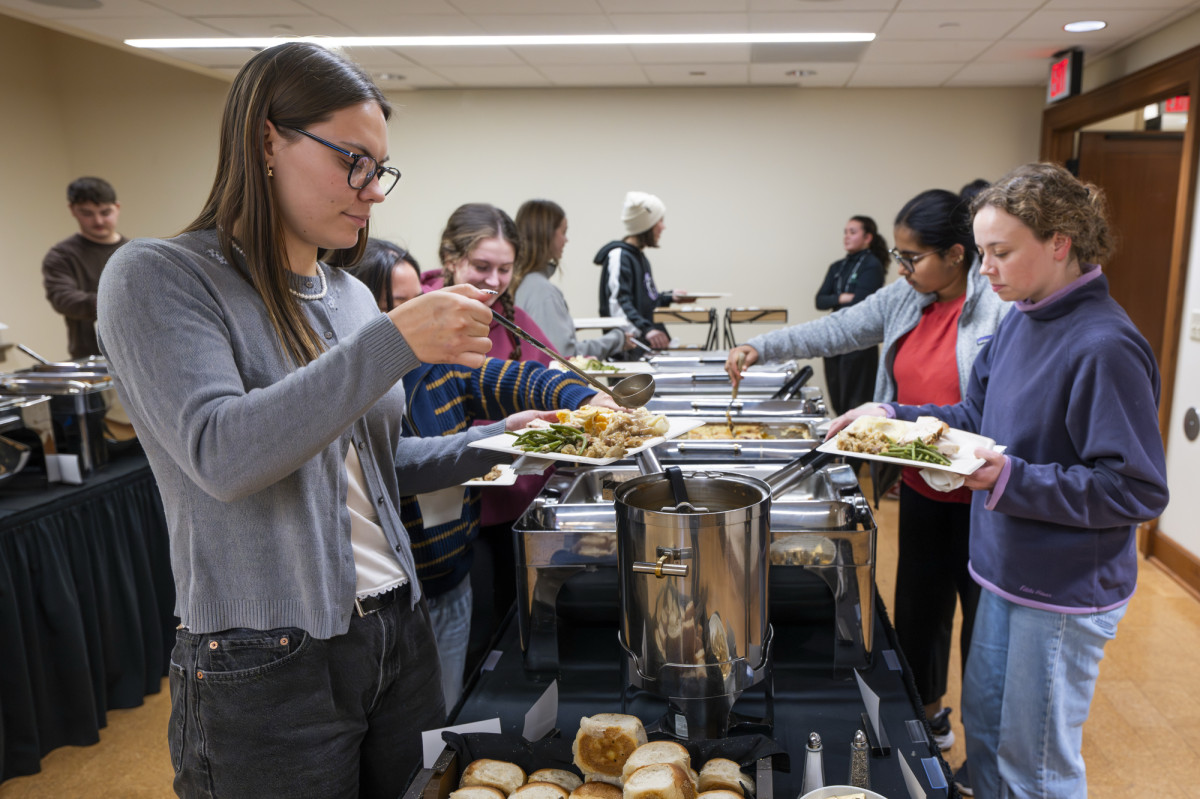 Students stand on either side of a buffet line inside a room in the Memorial Union.