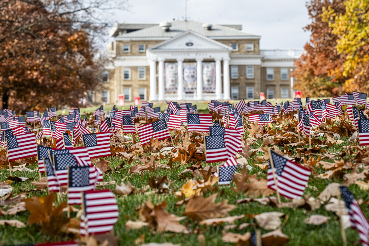 A view of Bascom Hill covered with small American flags and Bascom Hall in the background.