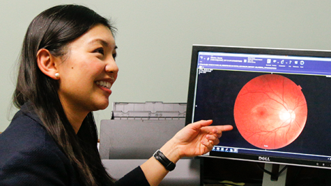 Yao Liu points to a retinal scan on a computer monitor.