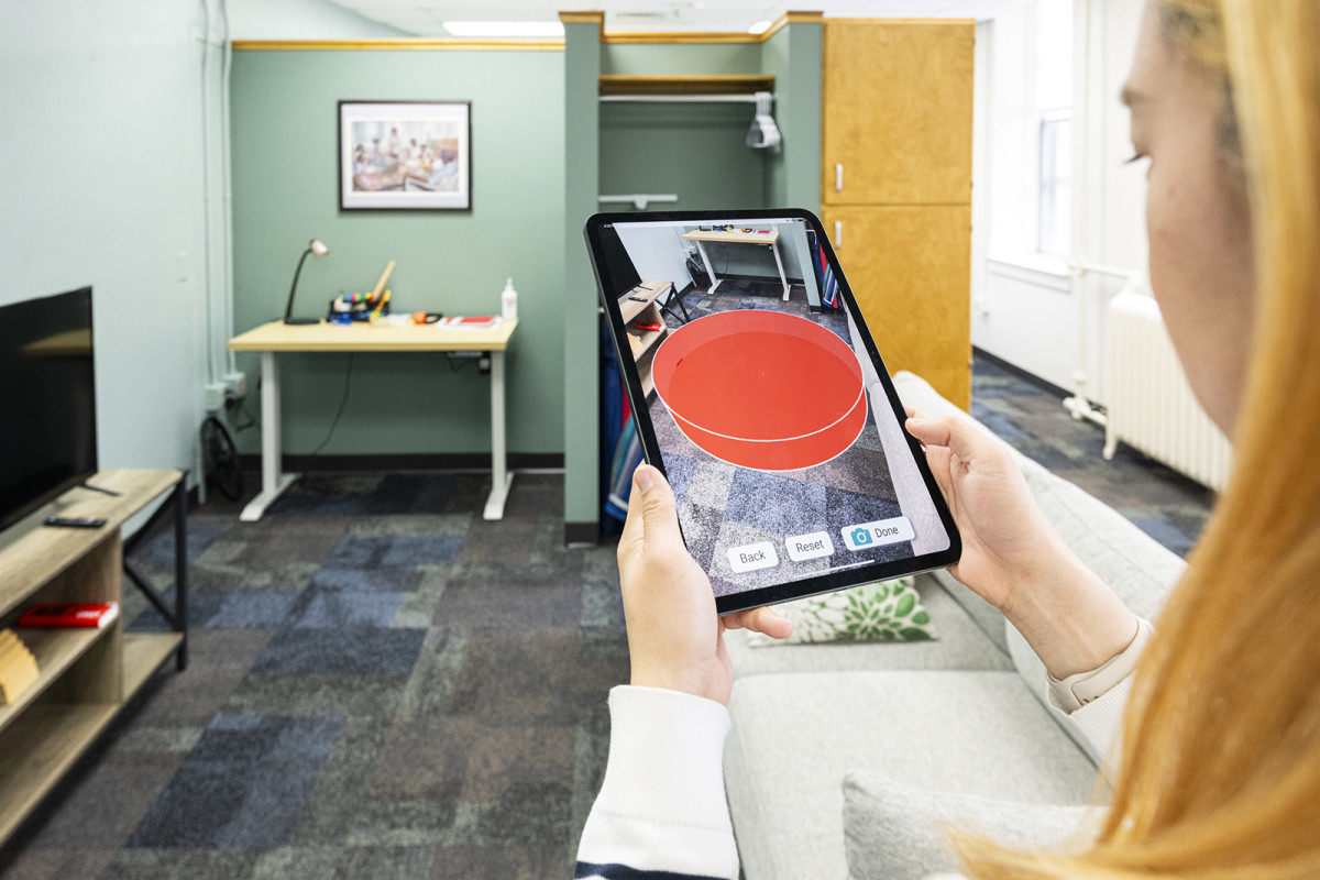 Graduate student Dowon Lee demonstrates a new app on a tablet that displays a camera view of the room