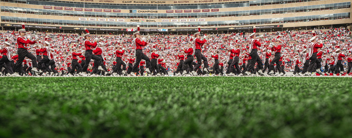 Marching band playing on a football field in Camp Randall Stadium
