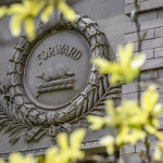 An architectural ornament on the outside of a wall with an illustration of a badger and the Wisconsin state motto 