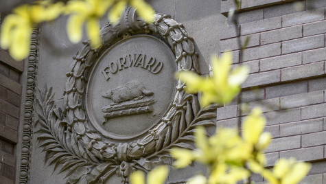 An architectural ornament on the outside of a wall with an illustration of a badger and the Wisconsin state motto 