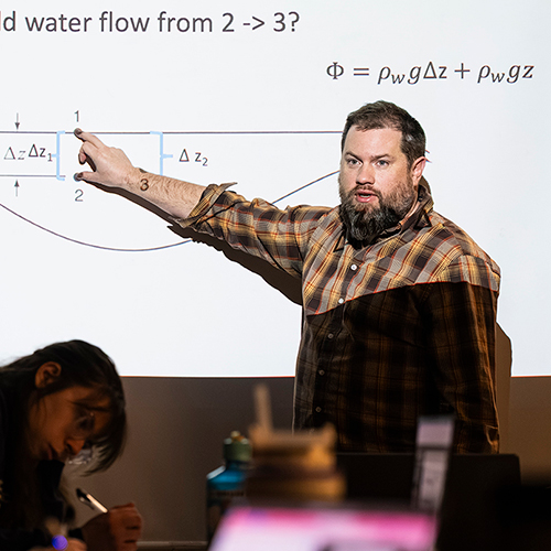 Professor pointing to a projected slide