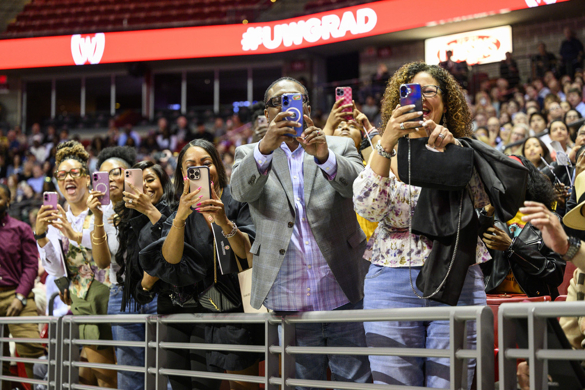 Group of people smiling and taking pictures with their phones