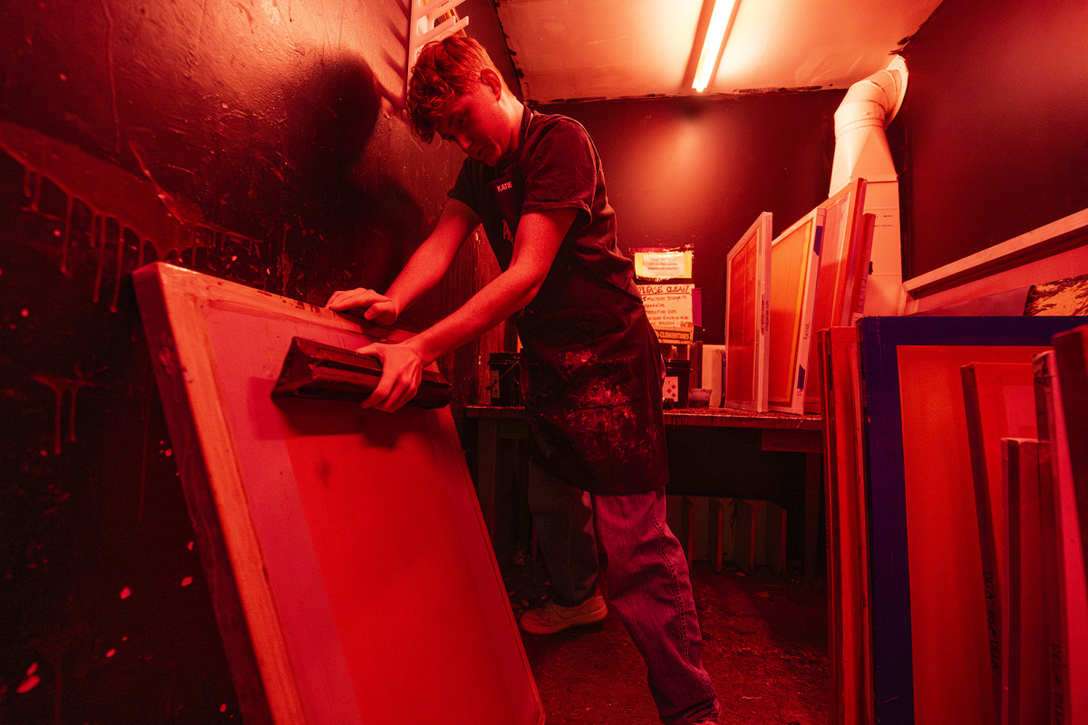A person working with a silkscreen used in printmaking