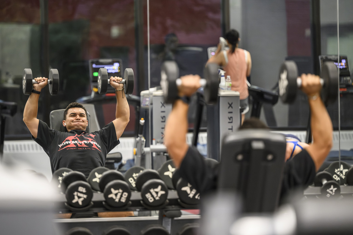 A person lifting weights while looking in a mirror