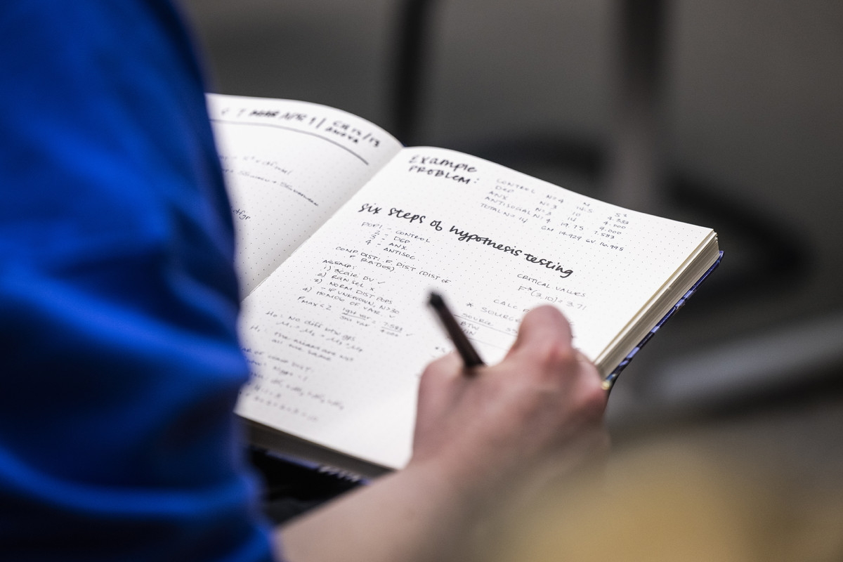 Close up of a person's hand writing in a notebook
