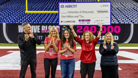 Chancellor Jennifer Mnookin holds a large ceremonial check while several people applaud.