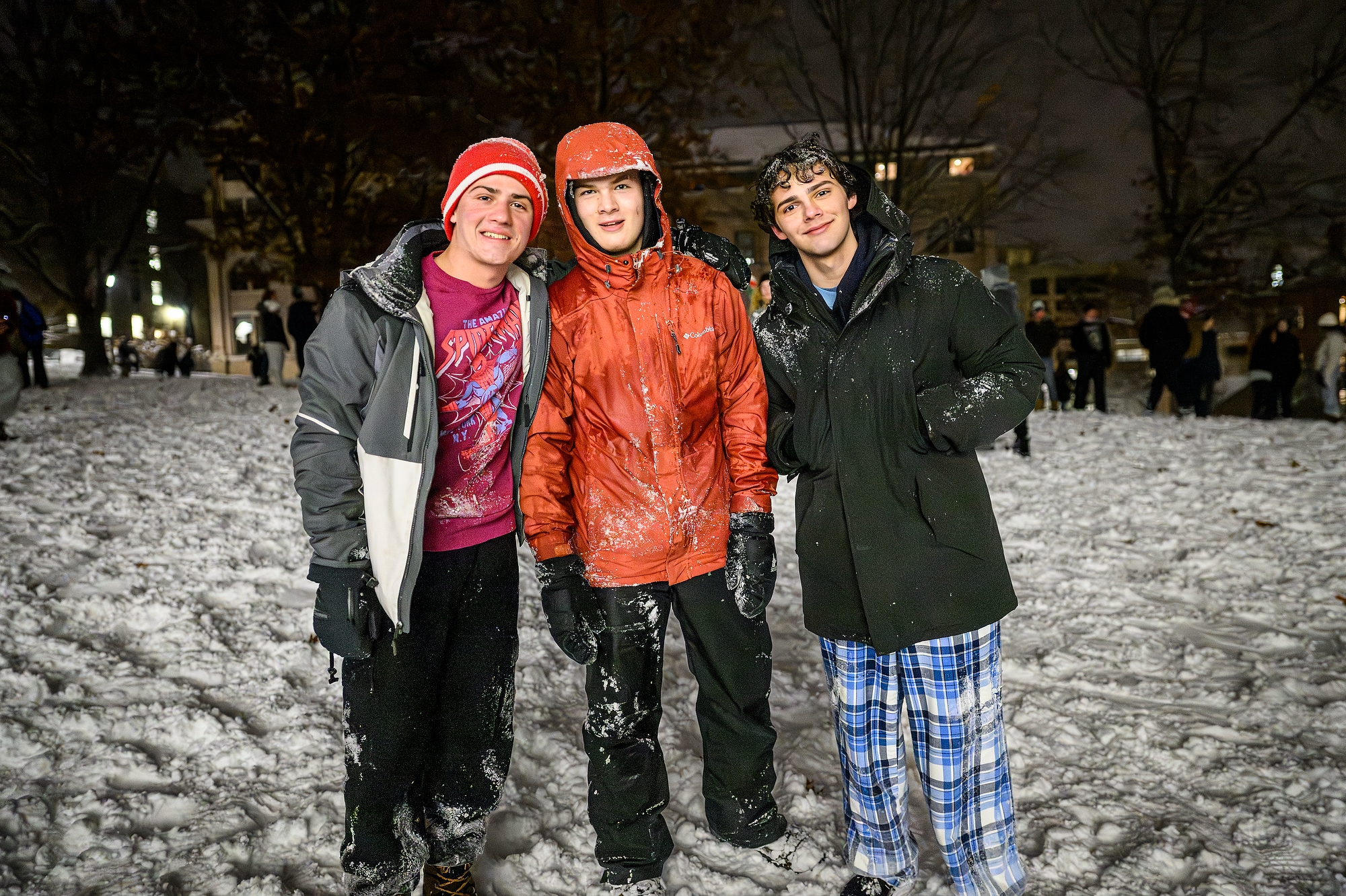 Three students smiling for a photo on snowy Bascom Hill