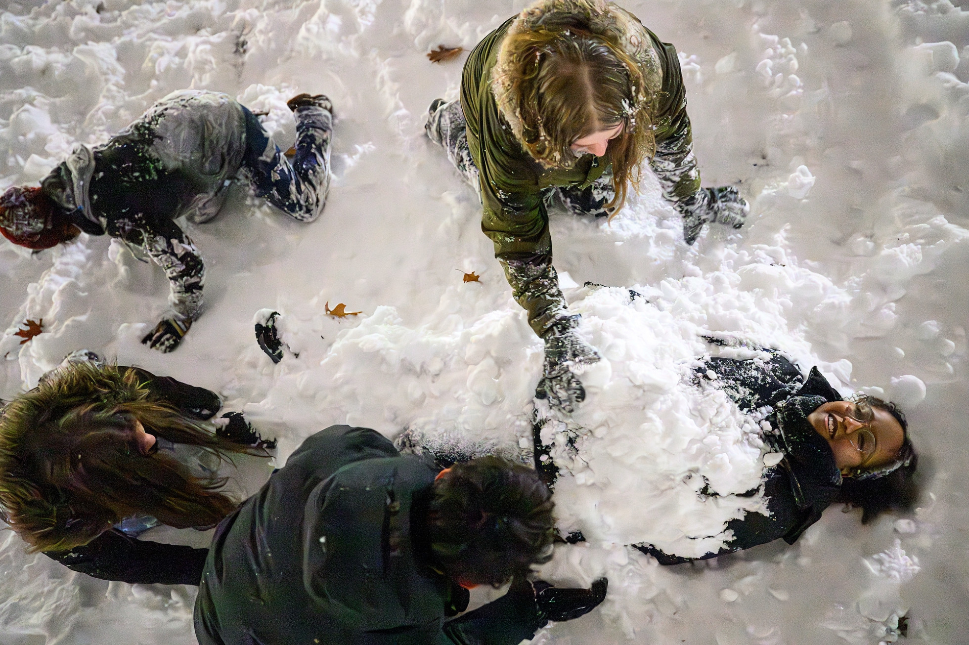 Students playfully burying their friend in the snow