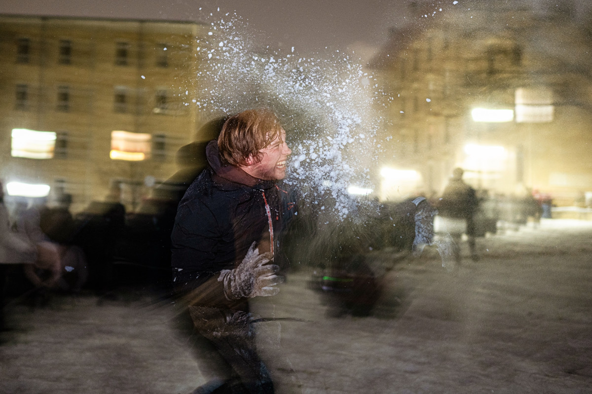 A student throwing snow on snowy Bascom Hill