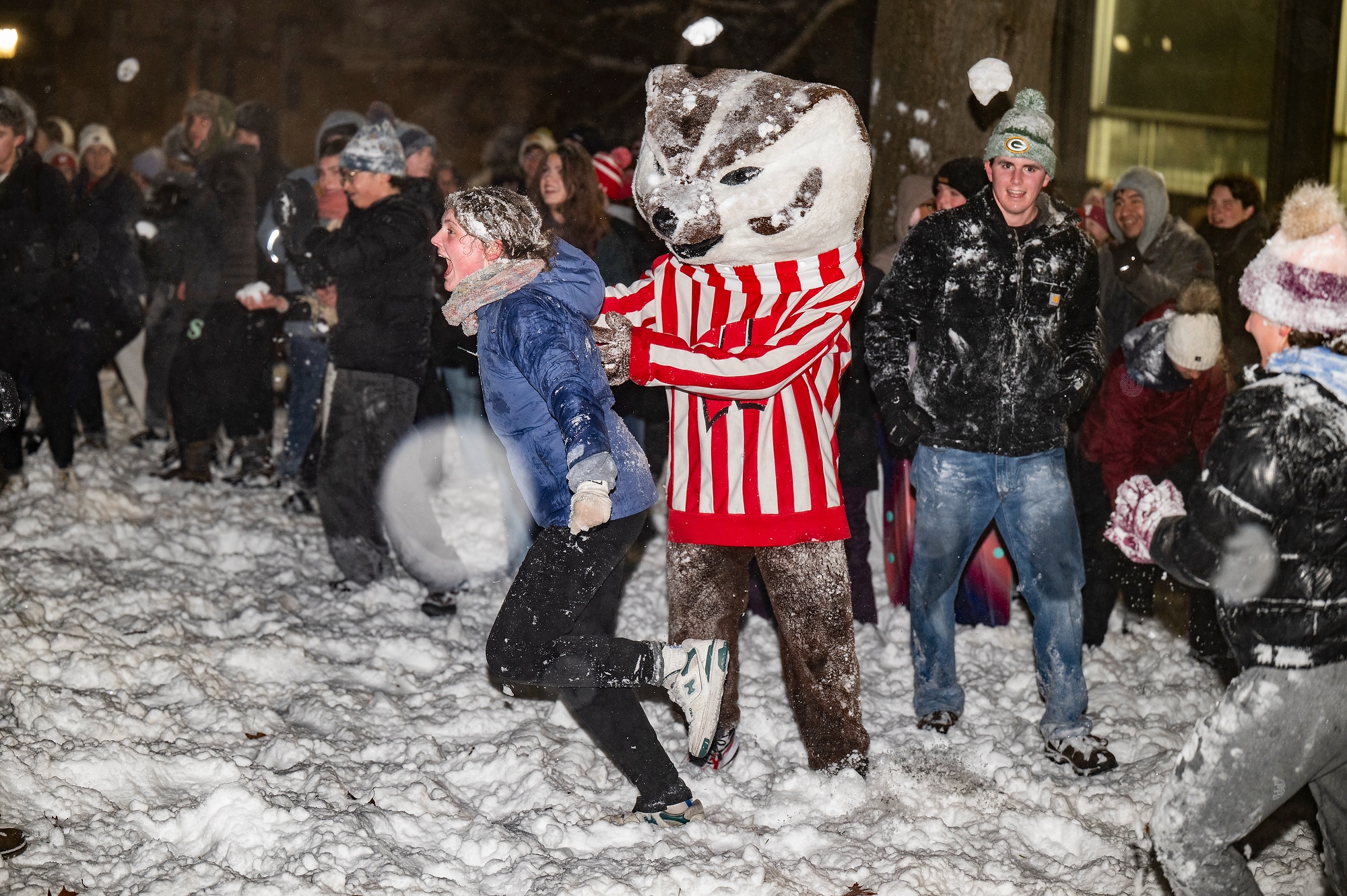 Bucky Badger playfully pushing a student away