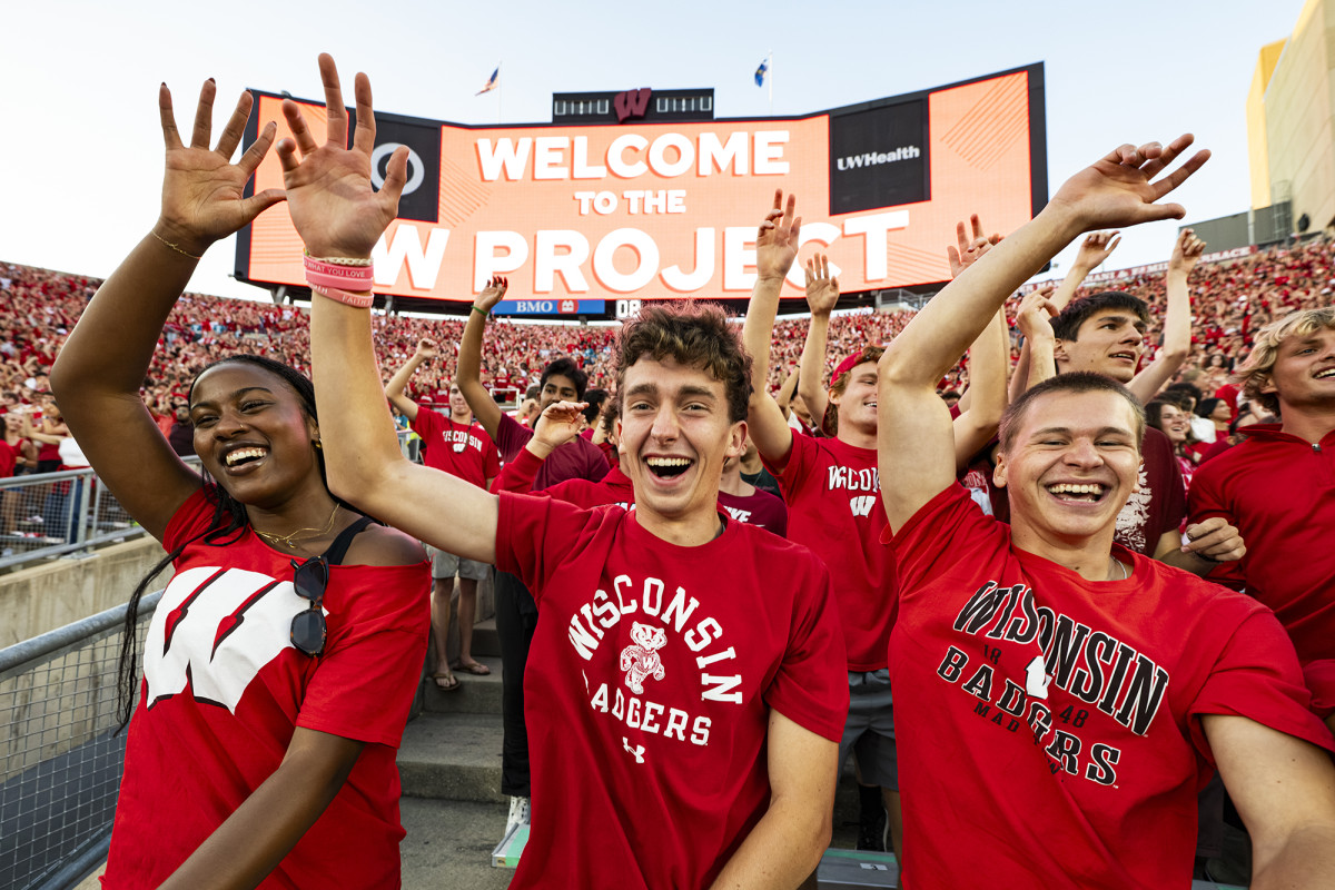 Happy group of students smiling with their hands in the air