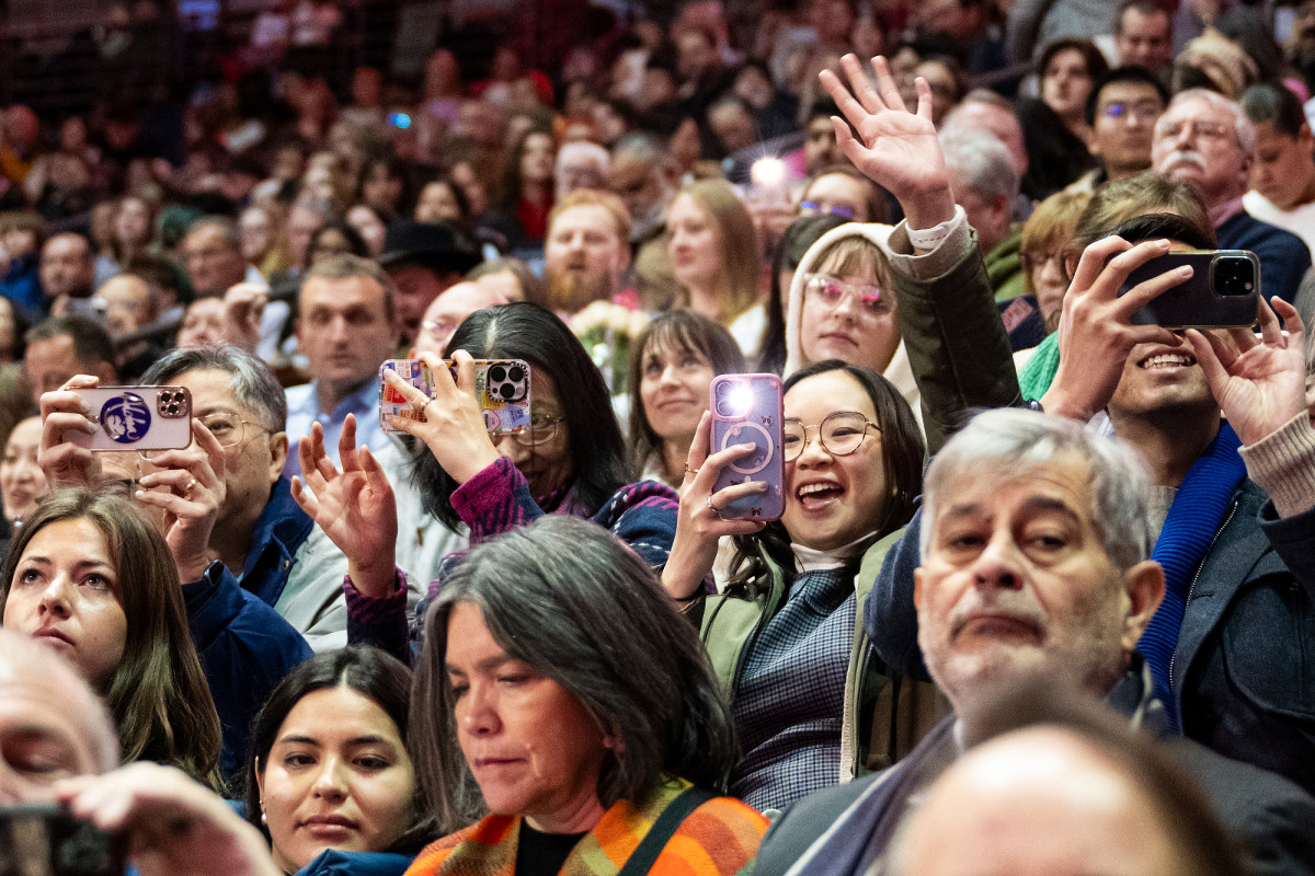A stadium full of proud friends and family take pictures and wave to their graduates.
