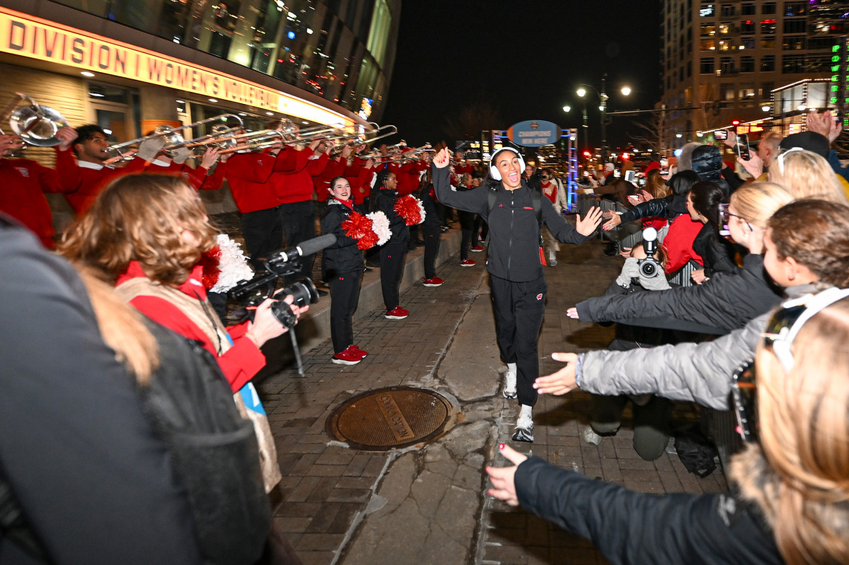 Volleyball player Grace Egan holds up her hand in celebration with fans outside of the T-Mobile Center. 