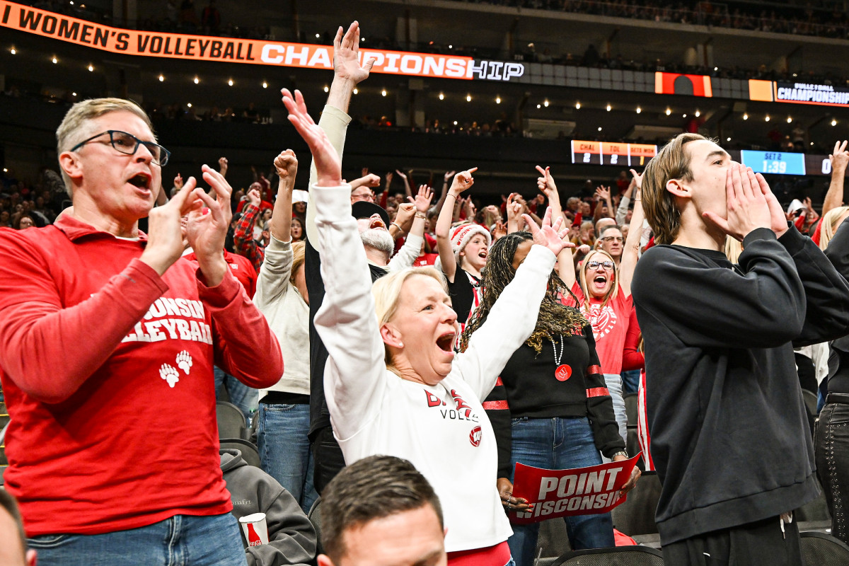 Badger fans clap and wave their hands in the air during the volleyball match. 