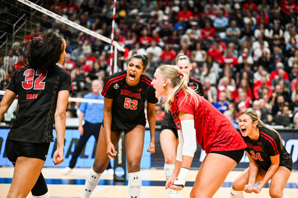 Volleyball player Carter Booth yells and celebrates with her teammates. 