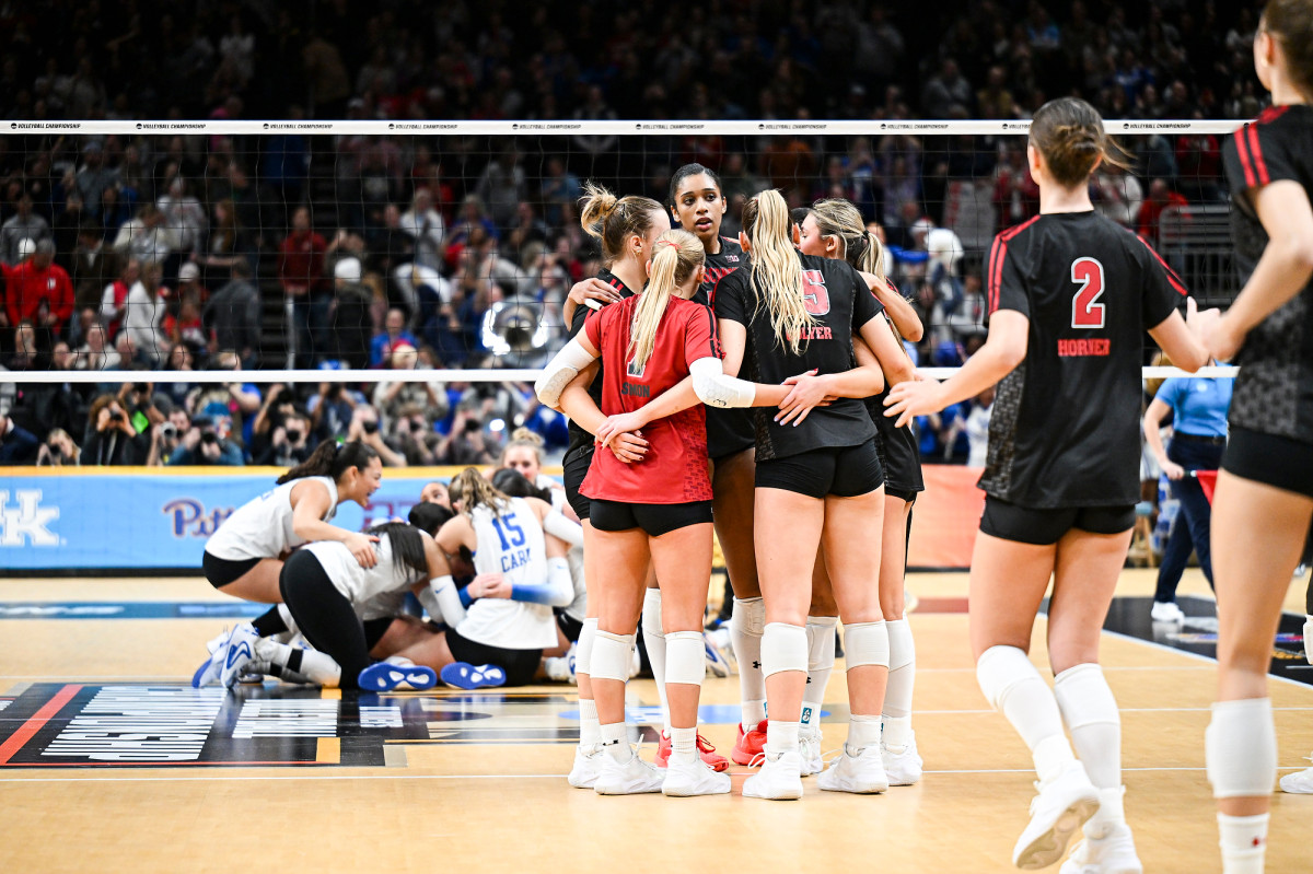 Badger players embrace each other in a group hug after the game. 