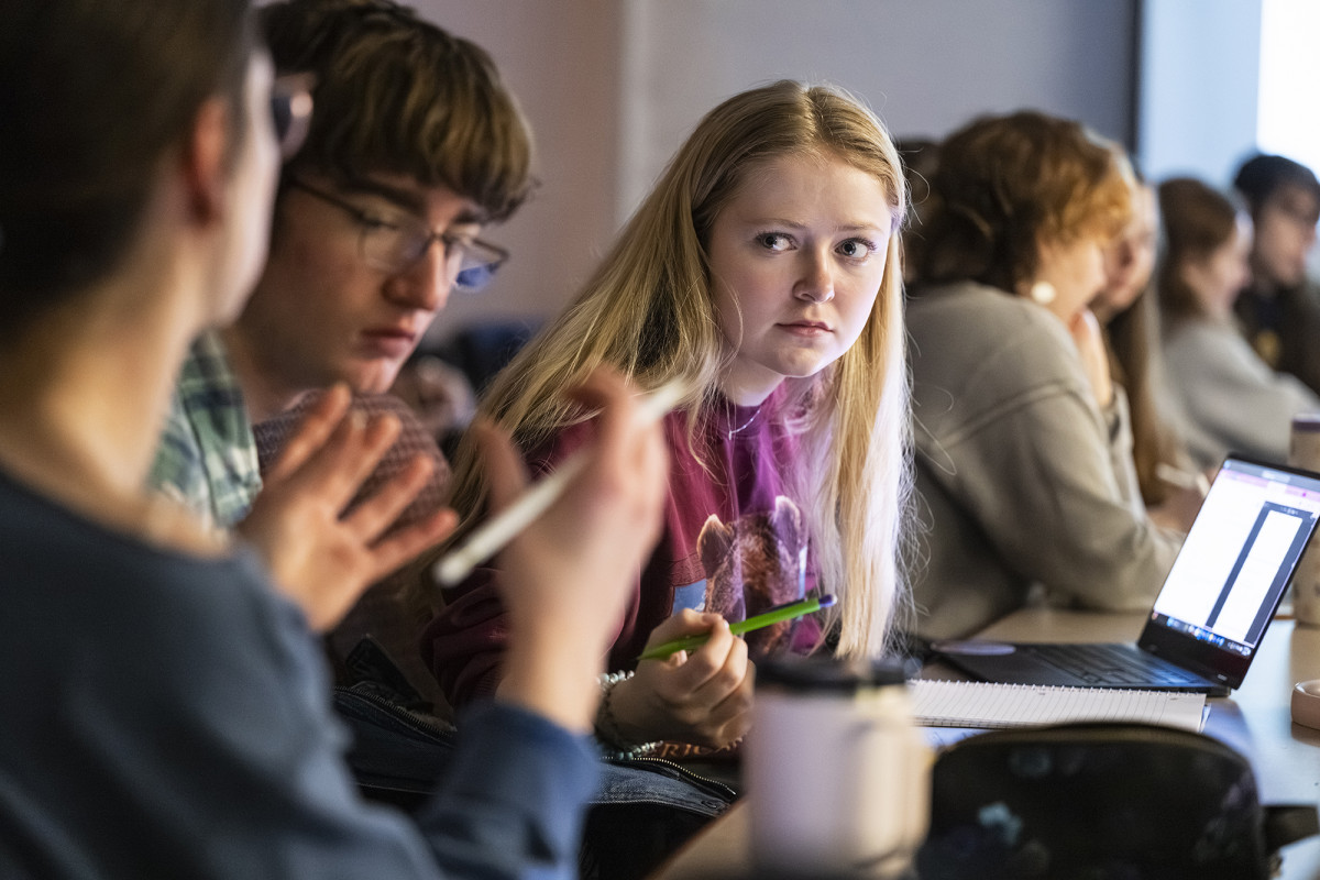 A student looking intently at another person who is talking