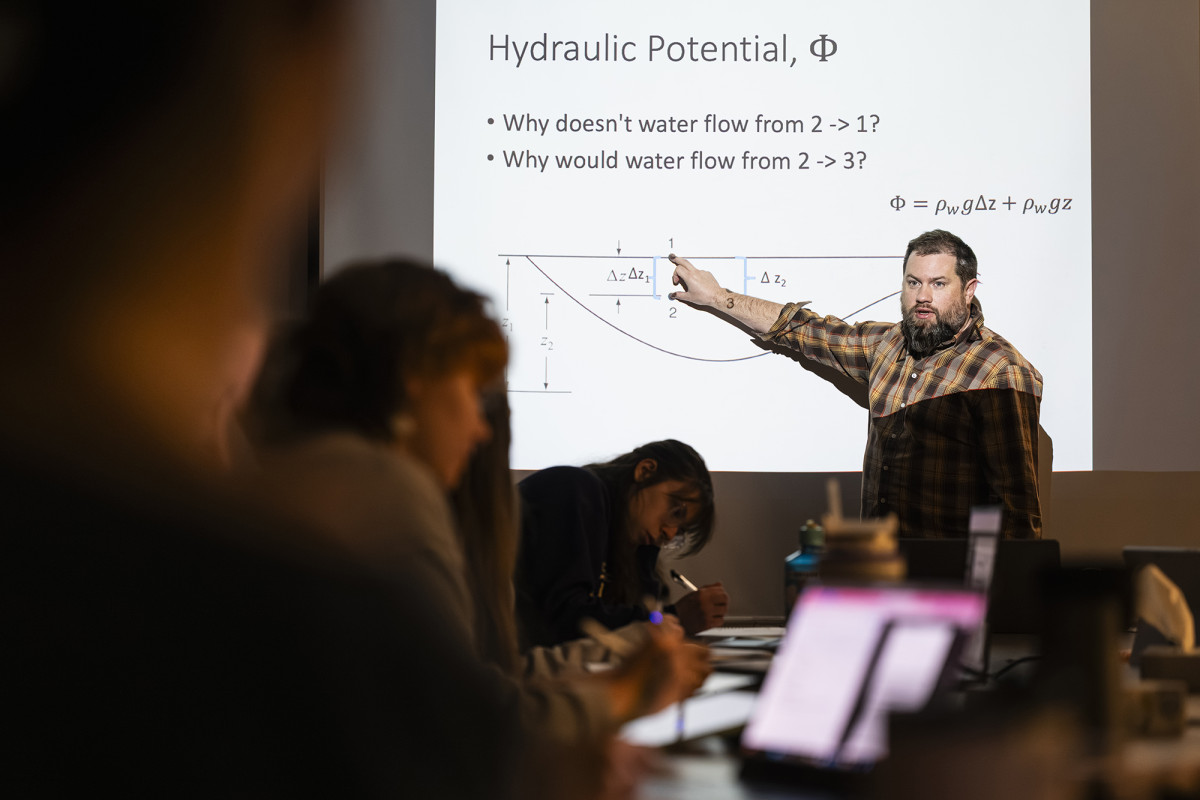 A professor pointing at a chart on a projected slide