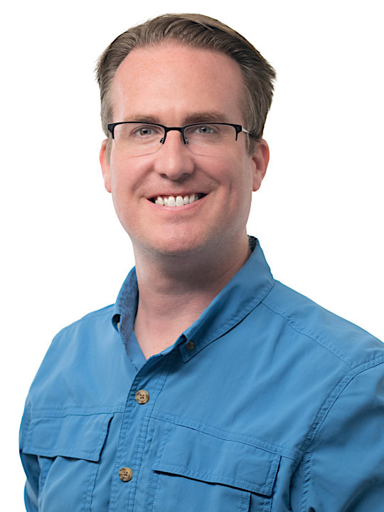 Dan Ludois wearing a blue button-up shirt, posed against a plain white background.
