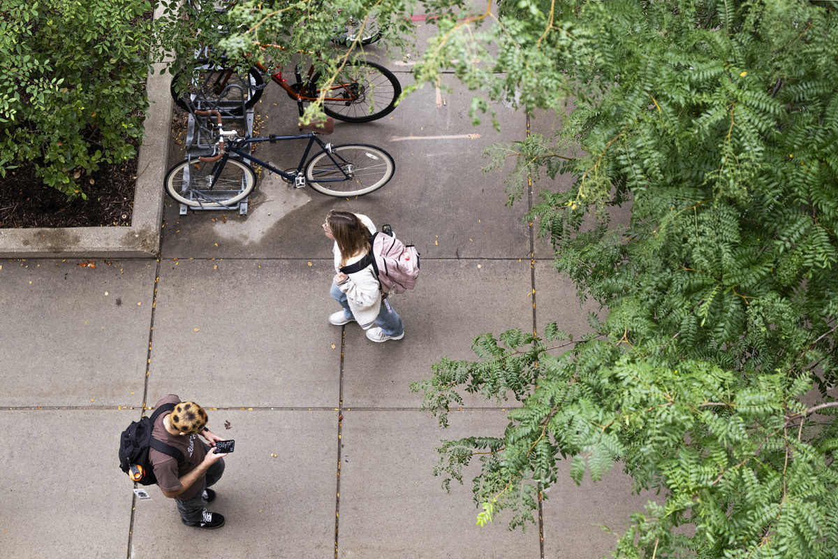 Overhead view of two students walking on a sidewalk