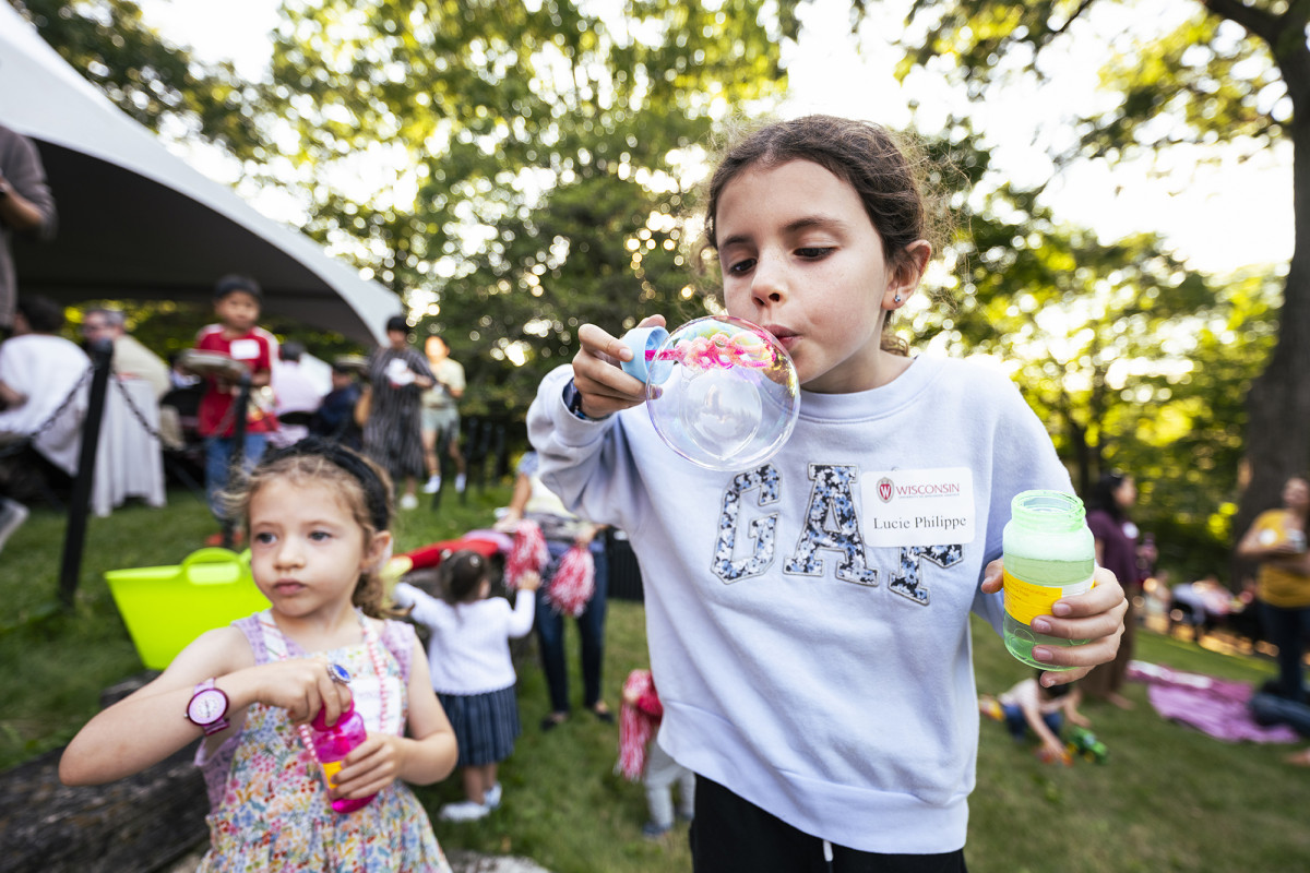 Two children blowing bubbles outdoors