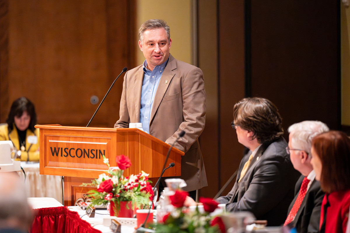 A man stands at a podium speaking.