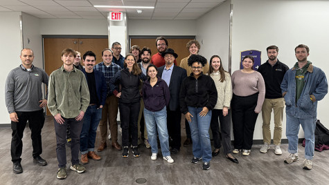 A group made up of UW graduate students and their professor and public service works stand together for a photo.